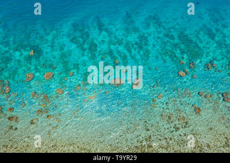 Transparent sea water, top view. Aerial view of calm sea water. Top view of a clean ocean water near a coast. Stock Photo