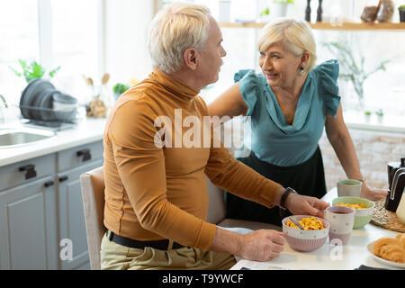 Happy contended beaming nice-appealing attractive elderly spouses talking during breakfast Stock Photo