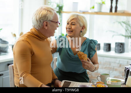 Beaming loving spouses having tasty breakfast and conversation Stock Photo