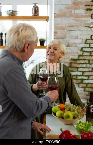 Talented aging white-haired bearded spouse engaging in cooking a dinner Stock Photo