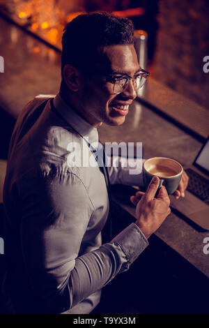 Handsome freelancer smiling having little coffee break Stock Photo