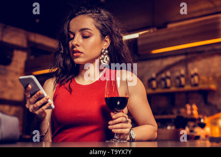 Dark-haired pretty woman reading message from boyfriend Stock Photo