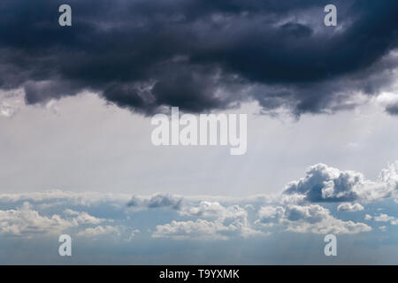 Storm clouds near horizon on blue sky at daylight in continental europe. Shot wit telehoto lens and polarizing filter. Stock Photo