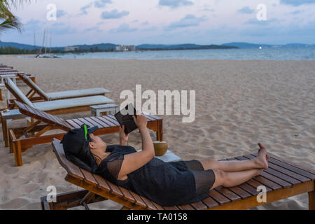 Young tourist use tablet on the beach Stock Photo