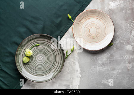 Stylish plates with napkin on grey background Stock Photo