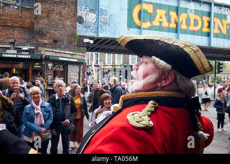 London / UK - May 18th 2019: A town crier in uniform calls out to the crowd in Camden Market, London. Stock Photo
