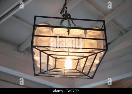Hanging a dozen of bottles lamp on vintage ceiling Stock Photo