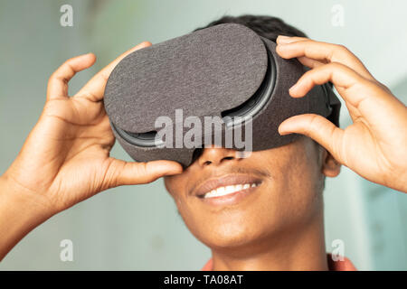 Closeup of a young man experiencing virtual reality through a VR headset Stock Photo