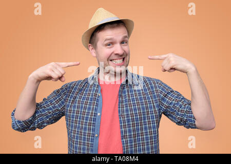 Young man in summer hat shows on his teeth. Stock Photo