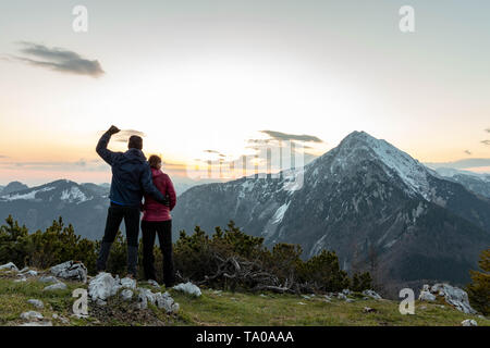 Young hikers enjoying in sunrise high up in the mountains Stock Photo