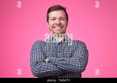 young man in shirt standing with arms crossed Stock Photo