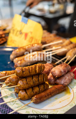 Sai Ua, the northen thai sausage on some wooden stick on a plate at a market in Chiang Mai, Thailand Stock Photo