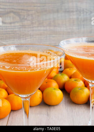 freshly squeezed tangerine juice in glass on rustic wooden background Stock Photo