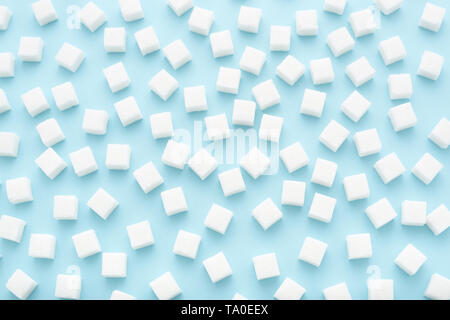 Abstract pattern made of white sugar cubes scattered on light blue background. Minimal style. Trendy pastel color. Stock Photo