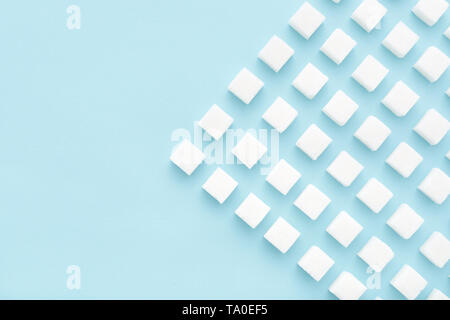 Sugar cubes abstract pattern on light blue background. Copy space, top view, minimal style. Ebergy concept. Stock Photo