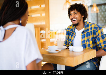 Laughing young couple in cafe, having a great time together Stock Photo