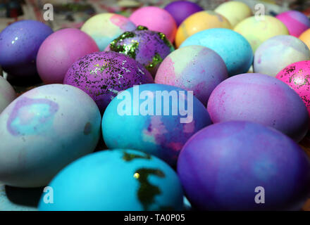 An assortment of colored and decorated eggs drying on newspaper. Stock Photo