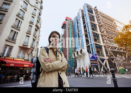 Young girl in a yellow jacket in front of the Pompidou Center in Paris