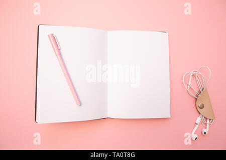 Opened empty diary with pink pen on pastel millennial pink paper background. Concept education, blogging. Top view. Flat lay. Minimal style. Stock Photo