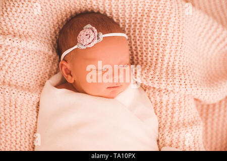 Smiling cute baby girl sleeping swaddled in crib closeup. Healthy napping. Good morning. Stock Photo