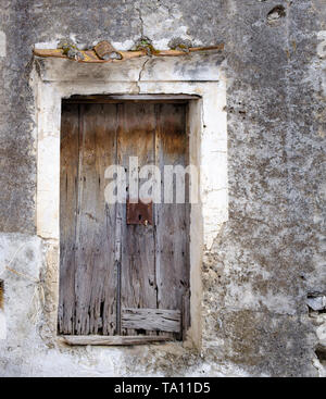 Ancient worn out dilapidated weathered faded wooden door with rusty lock Stock Photo