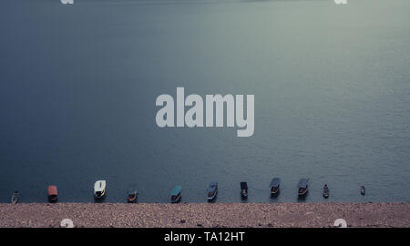 turquoise water still surface with typical wooden boats on the lake beautiful landscape nature. Stock Photo