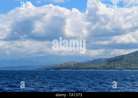 BALI, INDONESIA - December 01, 2013: Approaching the coast of Lombok, Balis neighbouring Island, by Boat on a beautiful day blue skies. Stock Photo