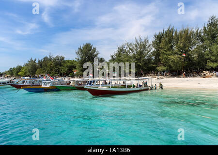 GILI TRAWANGAN, INDONESIA - December 01, 2013: Sandy Beach, clear Waters and Boats on Gili Trawangan. Stock Photo