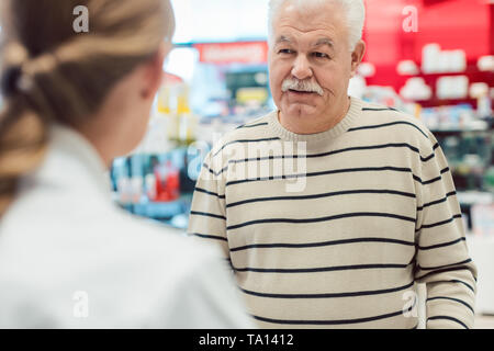 Senior man getting advice from pharmacist in pharmacy Stock Photo