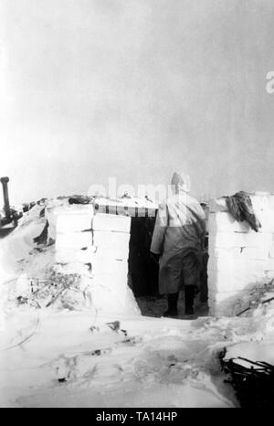 German soldier in front of his snowbound camp near the Leningrad Pocket. Photo of the Propaganda Company (PK): war correspondent Hoenig. Stock Photo