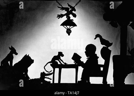 This photo shows a scene from the silhouette film 'Dr. Dolittle and His Animals' - subtitle: 'Der Tierdoktor in seinem Heim' by Charlotte Reiniger. The silhouette film, also known as silhouette animation, is a technique of animated film in which silhouettes are put together on a lighted glass plate in front of a white or black background to form a film. The result is the silhouette film, inspired by shadow theater and the pictorial techniques of silhouette cutting. Stock Photo