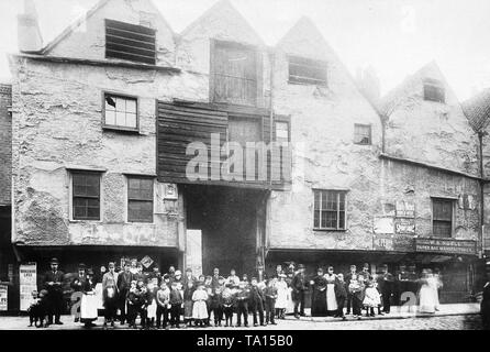 People posing for the camera in one of the oldest parts of London, circa 1890. It shows a number of famous old buildings from the 16th century in the Bermondsey Street Stock Photo