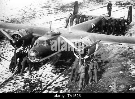 Ground crew on a Dornier Do 17 F combat aircraft (presumably 9) on an airfield. Undated photo, probably in the 1930s. Stock Photo