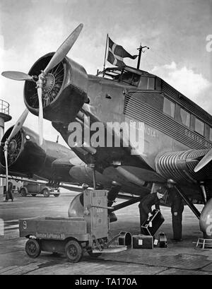 A Junkers Ju 52 of the Danish airline DAL at Berlin-Rangsdorf Airport. Luggage is loaded into the cargo hold. Stock Photo