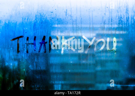 Thank you words rain drops water drops written wrie on window glass blue tone blur nature bokeh background Stock Photo