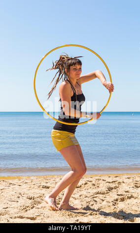 Southbourne, Bournemouth, Dorset, UK. 21st May 2019. UK weather: lovely warm sunny morning as Lottie Lucid performs her hula hooping routine on the beach at Southbourne, enjoying the warm sunny weather in her mini skirt. Credit: Carolyn Jenkins/Alamy Live News