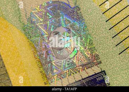 21 May 2019, Hessen, Frankfurt/Main: A portrait hologram (M) of the pearlescent strip on the revised 100 euro banknote can be seen during the presentation of the new 100 and 200 euro banknotes at the Bundesbank. The new notes have new security features and are narrower than the previous notes. At the end of May, 100 and 200 euro notes with additional security features will be put into circulation. Photo: Boris Roessler/dpa Stock Photo