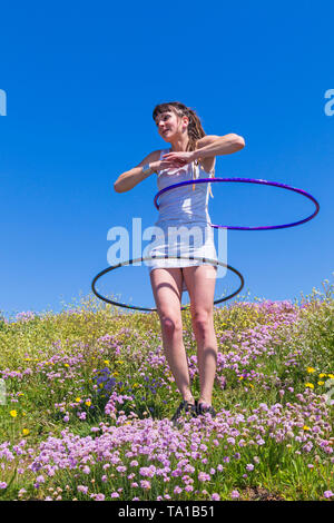 Southbourne, Bournemouth, Dorset, UK. 21st May 2019. UK weather: lovely warm sunny morning as Lottie Lucid performs her hula hooping routine on the seafront cliffs at Southbourne among the wildflowers, Sea Thrift, Armeria maritime, enjoying the warm sunny weather in her mini dress. Credit: Carolyn Jenkins/Alamy Live News