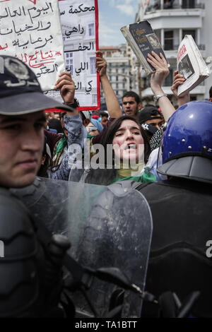 Algiers, Algeria. 21st May, 2019. Algerian students hold placards and shout slogans, surrounded by members of the riot police during an anti-government demonstration. Algeria's military chief of staff on Monday rejected calls to postpone the country's presidential elections, slated for 04 July to elect a successor to ousted president Abdelaziz Bouteflika. Credit: Farouk Batiche/dpa/Alamy Live News Stock Photo