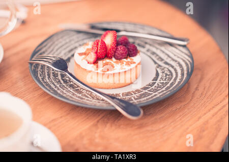 Cake with fresh strawberries on plate in cafe close up. Good morning. Tasty breakfast. Stock Photo