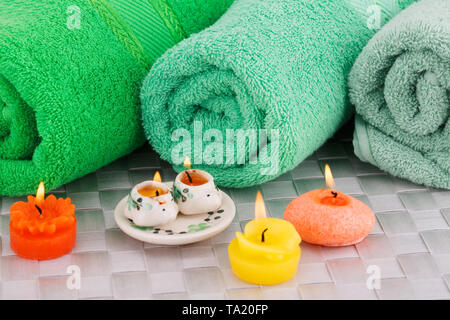 Spa set with towels and candles on bamboo background. Stock Photo