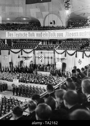 Mass rally of Air Force. Nazi Air Force Corps and Hitler Youth at the opening of the propaganda week of the Luftwaffe. Above the flag-bearer a flag of the Luftwaffe, above the banner reading 'Das deutsche Volk muss ein Volk von Fliegern' (The German nation must become a nation of fliers). Stock Photo