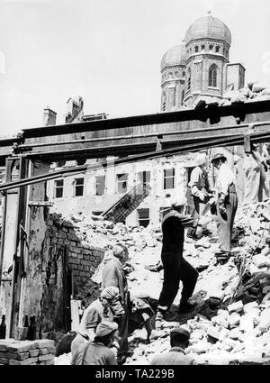 The lack of technical resources forced the people to eliminate the millions of cubic meters of rubble by hand. As here in Munich against the backdrop of the towers of the Frauenkirche, so toil throughout the German cities thousands of men and women on the mountains of rubble left by the war. Stock Photo