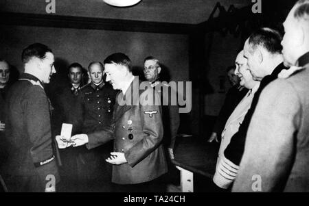 Adolf Hitler grants Colonel Ulrich an award in the 'Adlerhorst' headquarters in Taunus. In the background from left to right: Joachim von Ribbentrop, Hermann Fegelein, Alfred Jodl, Wilhelm Keitel, Hermann Goering, Karl Doenitz and Heint Guderian. Stock Photo