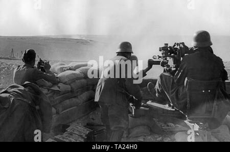 Undated photo of an antiaircraft unit of the Condor Legion during the deployment in the Spanish Civil War. Two men aim at ground targets with a 2cm FLAK 39 in a sandbag position. On the left in the front there are crates of ammunition. The soldiers are wearing M35 steel helmets. Stock Photo
