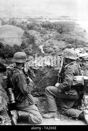 German soldiers kneel on a hill above the river Mius at the southern sector of the Eastern Front, 1943. Photo of the Propaganda Company (PK): war correspondent Caspar. Stock Photo