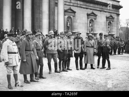 The leaders of the Freikorps, who were actively involved in the Beer Hall Putsch (Hitler putsch) of 1923 gather on the Munich Koenigsplatz on the 10th anniversary of the coup. The flags of the Freikorps are handed over to SA leader Ernst Roehm. The picture shows the Freikorps leaders with steel helmet, Franz Pfeffer von Salomon, Heinz Hauenstein, Gerhard Rossbach, Kurt Kuehme, Hubertus v. Aulock.In the background, the Propylaea. Stock Photo