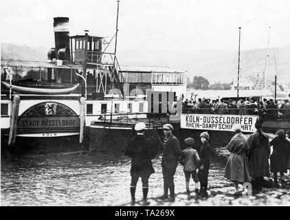 Expellees from the Ruhr area are waiting on the boat dock for a steamer of the Cologne-Duesseldorf Rhine steamship (Undated photo). Stock Photo