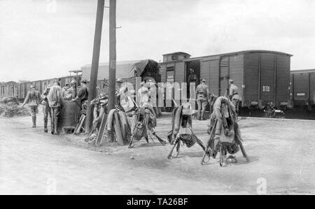 Soldiers of the French occupation force pack their luggage onto trains. At the station there are several rifles which had been arranged in pyramids and knapsacks. Stock Photo