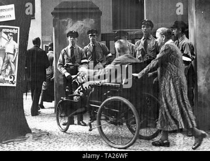 Voters in Potsdam on their way to the polling station in Mirbachstrasse on the occasion of the Reichstag election. On the right in the background there are members of the Bismarck Youth of the German National People's Party with an election poster on which stands 'With Hugenberg German National'. On the left in the foreground on a tree is an election poster of the National Socialists, on which stands 'Workers wake up!'. Stock Photo